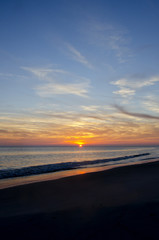 Fototapeta na wymiar Sun Dips Below Horizon on the Beach