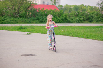 A girl on the road quickly rides a scooter on a summer day © viclin
