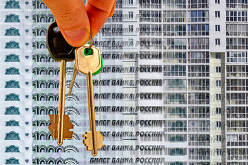 The keys to the apartment on a background of money and houses . The concept of mortgage lending .