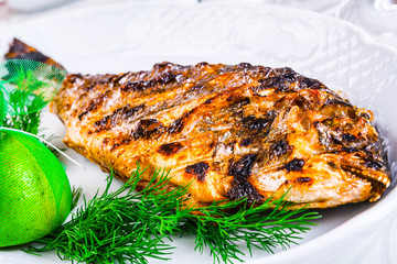 Grilled dorado fish on white plate