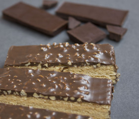 wafer chocolate cake and chocolate pieces on a wooden table