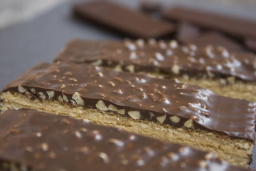 wafer chocolate cake and chocolate pieces on a wooden table