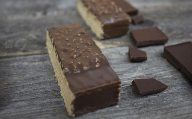 wafer chocolate cake and chocolate pieces on a wooden table