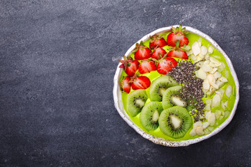 Breakfast Detox Green Smoothie  Bowl with fresh berries,kiwi and chia seeds. Food or Healthy diet concept on the gray background.Super Food.selective focus.