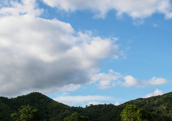 blur image - view of the forests on the mountain with fog on blue sky with cloud background