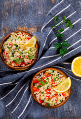 Tabbouleh salad with couscous on the plate.Traditional middle eastern or arab dish.Vegetarian.Parsley,pepper,cucumber,tomato,lemon.Middle eastern meze.Food or Healthy diet concept.Copy space for Text.