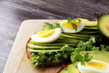 Sandwich with avocado and poached egg - healthy breakfast concept