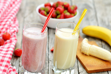 Strawberry and banana milkshake smoothie in the glass with straw