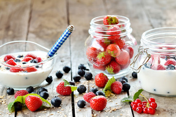 White yogurt in a bowl with oatmeal, blueberries, raspberries and strawberries