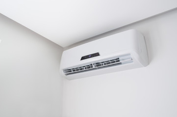 White split air conditioner on a white wall. Home interior in a small apartment