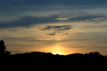 Beautiful sunset over the silhouetted mountains trees