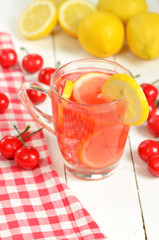 Fruit cherry tea with slice of lemon in mug and cherries