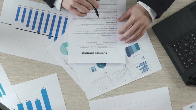 Successful deal between two businessmen, men signing business contract, top view