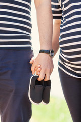 Baby booties for the newborn in the hands of future parents