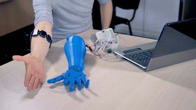 An engineer walks a robotic hand through different motions.