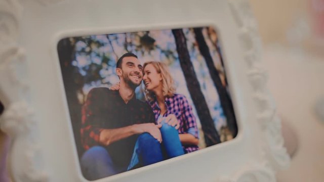 Photo of young happy couple in the frame. Decoration of the table.