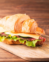 Sandwich with smoked salmon, cucumbers and cheese on the board, vertical, selective focus, closeup