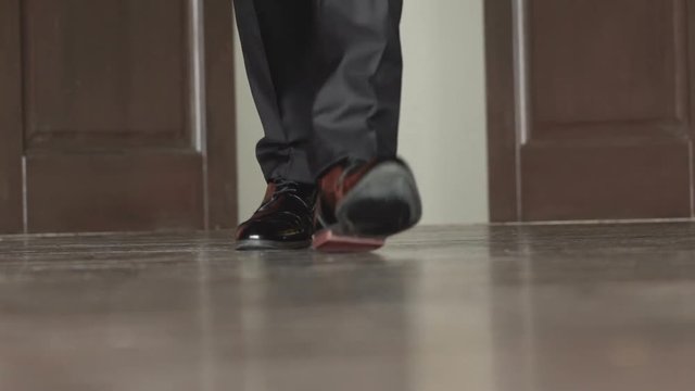 Unrecognizable businessman walking in the office. Slow motion