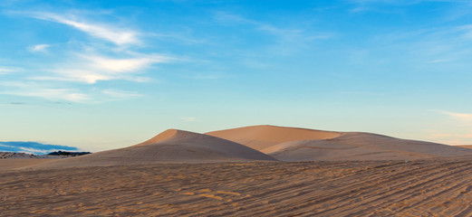 Fototapeta na wymiar Desert sand dunes road at sunset