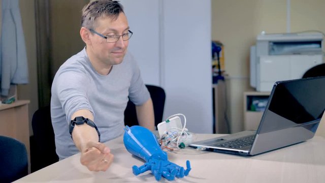 An engineer learns the abilities of a bionic arm.
