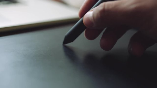 Designer working on a laptop with a graphics tablet. Closeup