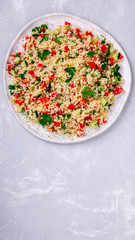 Tabbouleh salad with couscous on the plate.Traditional middle eastern or arab dish.Vegetarian.Parsley,pepper,cucumber,tomato,lemon.Middle eastern meze.Food or Healthy diet concept.Copy space for Text.
