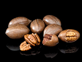 Pecans on shiny black background. Beautiful nuts.