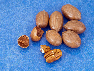 Pecans on blue shiny background. Said to help reduce cholesterol.
