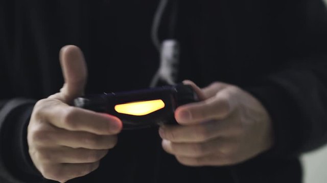 Man playing with a videogame controller in his hands. 4K