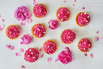 Pink dessert on white wooden table with pink roses