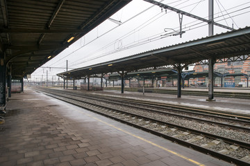Railway station platform and train tracks with awning above, Belgium.