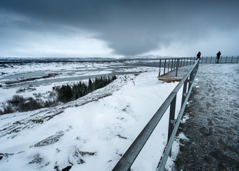 Bleak snowy landscape, road and stormy sky at day, Iceland, Europe.