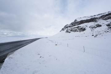 Snow covered landscape and road, diminishing perspective by day, Iceland, Europe.