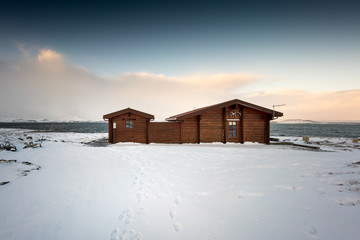 Cosy log cabin retreat in snow covered landscape, Iceland, Europe.