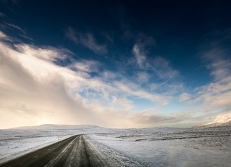 Snow covered landscape and curved road, diminishing perspective, Iceland, Europe.