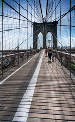 View along Brooklyn bridge with pedestrians walking, New York, USA.