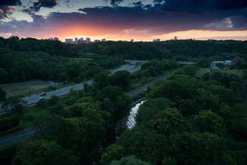 Skyline at sunset in background, roads through trees in foreground, Ontario, Canada.