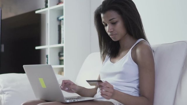 Young woman with credit card and laptop doing online shopping. 60 fps (for slow motion)