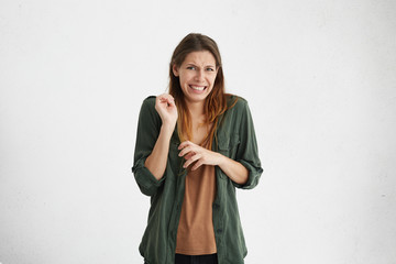 Brunette woman in casual clothes expressing disgust, unwillingness, dislike, disregard having...
