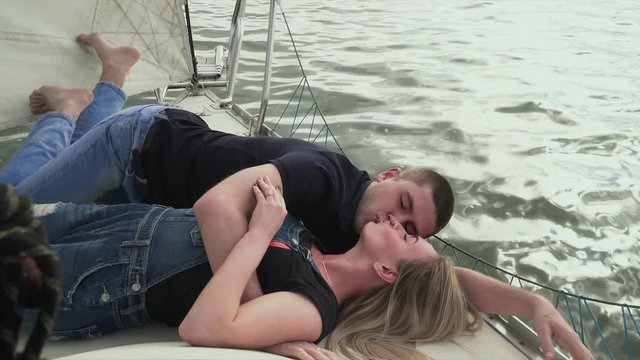 Young couple have a rest on the yacht. Romantic time of girl and boy on the nature together.