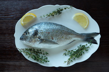 Fresh fish with lemon and thyme on a plate