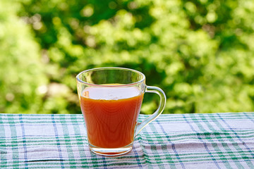 A glass of fresh carrot juice outdoors