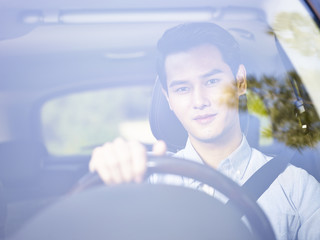 young asian man driving a car