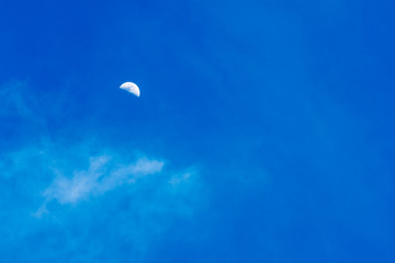 Moon in a cloudy night blue sky