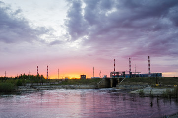 Gas power plant during sunset. Spillway and lake foreground. Energy industry concept.