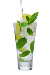 Pouring tonic into highball glass with ice crush, mint and lime