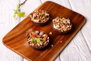 Tartlets with chocolate filling, cereal, nuts and mint