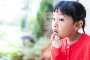 Little girl looking out for window