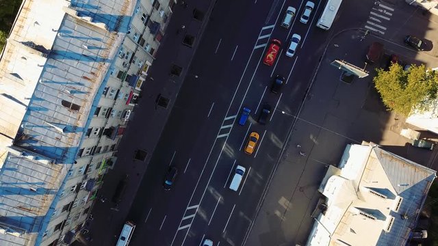 Aerial view. Crossroads in the downtown of city, vehicles drive through the solar part of the road, aerial view. St. Petersburg, Russia