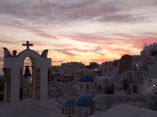 Fototapeta premium The church bell-tower against pastel color evening sky at Oia village, Santorini Island, Greece